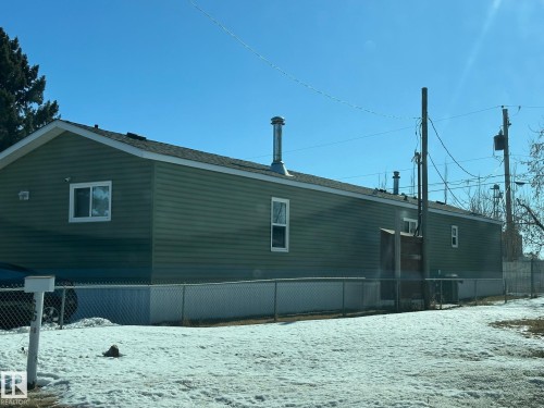 The property features green siding and white-trimmed windows - 67 4204 47 Street, Wetaskiwin, AB - Outdoor