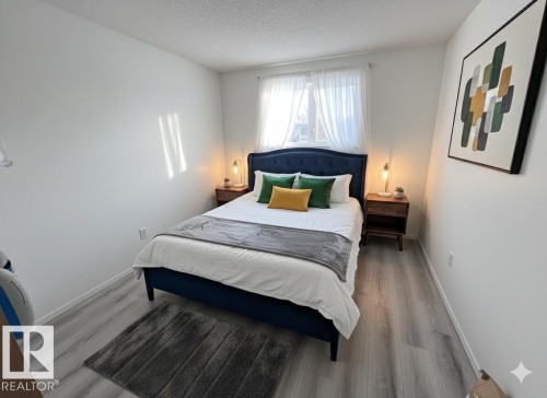 This room features light-toned flooring, white walls, and a window with sheer curtains - 212 2620 Mill Woods Road E, Edmonton, AB - Indoor Photo Showing Bedroom