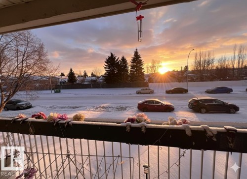 Enjoy picturesque neighborhood views from the balcony, featuring a metal railing and a partial view of a street - 212 2620 Mill Woods Road E, Edmonton, AB - Outdoor With View