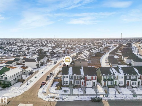 The property is a two-story residence with a light-colored facade and a dark roof, situated within a developed residential area featuring numerous similar homes - 1920 24 Street, Edmonton, AB - Outdoor With View