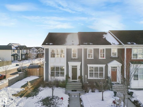 The property features a dark-colored exterior with white trim, a dark roof, and multiple windows across its facade - 1920 24 Street, Edmonton, AB - Outdoor With Facade