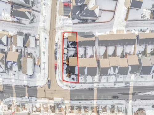 Aerial view showcasing the property outlined in red, featuring a rectangular lot, a residential building, and a driveway - 1920 24 Street, Edmonton, AB - Other