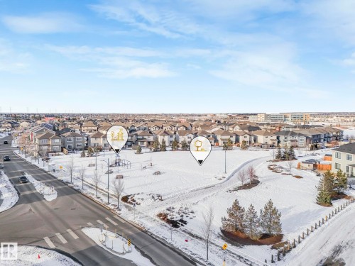 This property is located within a community featuring a public park with snow-covered grounds, trees, and benches - 1920 24 Street, Edmonton, AB - Outdoor With View