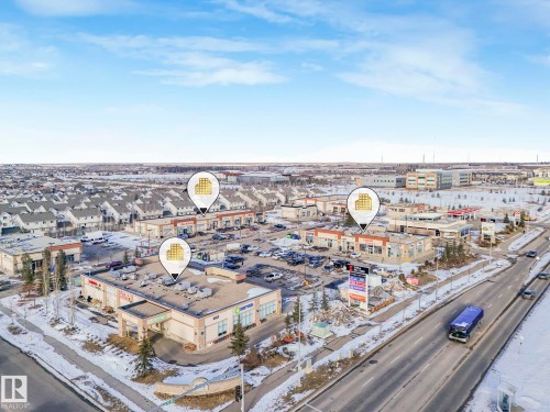 Aerial view showcasing the property's prime location within a commercial area, surrounded by other commercial buildings and a large residential neighborhood - 1920 24 Street, Edmonton, AB - Outdoor With View