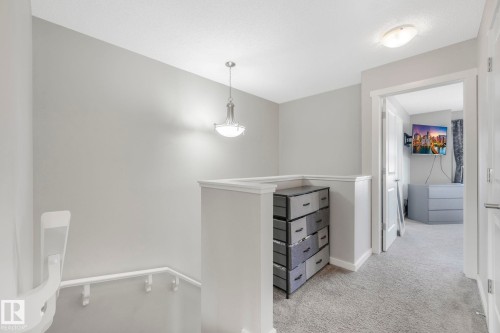 The property features a hallway with light gray walls, a textured ceiling, and a light fixture - 1920 24 Street, Edmonton, AB - Indoor Photo Showing Other Room