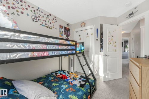 This bedroom features neutral-toned walls, a bunk bed with a ladder, and light-colored carpeting - 1920 24 Street, Edmonton, AB - Indoor Photo Showing Bedroom