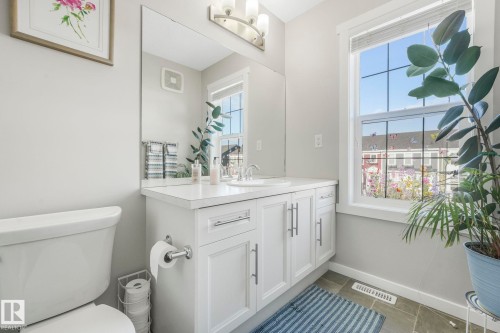 Bathroom featuring a white vanity with a white countertop and a mirror above - 1920 24 Street, Edmonton, AB - Indoor Photo Showing Bathroom