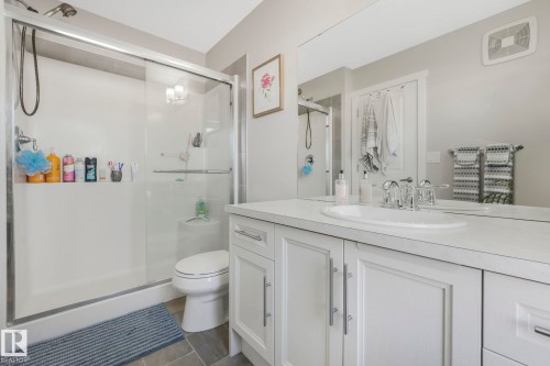 Bathroom featuring a spacious shower with a sliding glass door, a toilet, and a vanity with a white countertop and sink - 1920 24 Street, Edmonton, AB - Indoor Photo Showing Bathroom