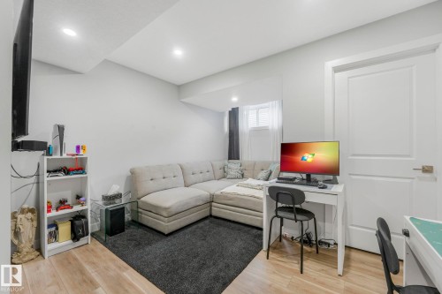 This room features light-colored walls and a combination of light wood flooring and dark carpeting - 1920 24 Street, Edmonton, AB - Indoor