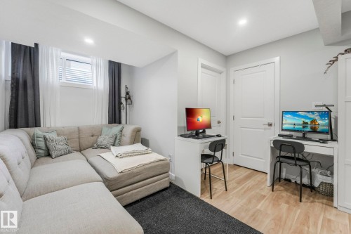 This versatile room features light-toned flooring, two white doors, and a window with blinds and curtains - 1920 24 Street, Edmonton, AB - Indoor