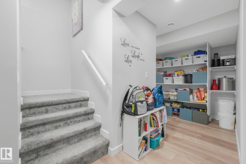 This inviting space features a carpeted staircase with a white handrail, leading to an area with light-colored flooring - 1920 24 Street, Edmonton, AB - Indoor Photo Showing Other Room