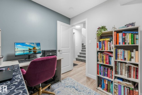 The property features light-toned flooring and a built-in bookshelf - 1920 24 Street, Edmonton, AB - Indoor Photo Showing Office