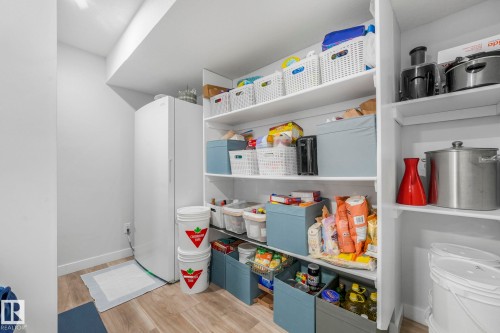 Well-organized pantry featuring extensive shelving, a white refrigerator, and light-toned flooring - 1920 24 Street, Edmonton, AB - Indoor