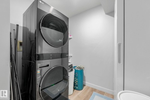 Laundry area featuring a stacked washer and dryer, light-colored flooring, and white walls - 1920 24 Street, Edmonton, AB - Indoor Photo Showing Laundry Room