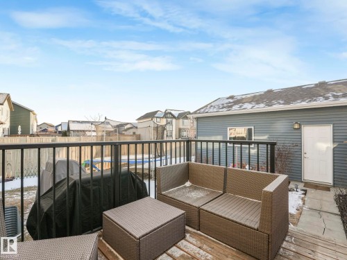 The property features an outdoor deck with a black metal railing, overlooking a fenced yard - 1920 24 Street, Edmonton, AB - Outdoor With Deck Patio Veranda With Exterior