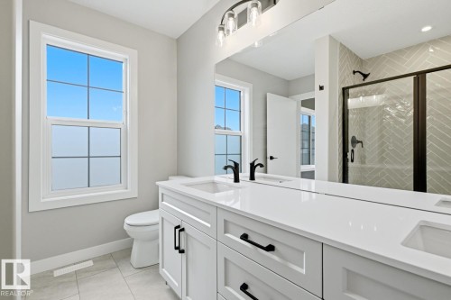 Double vanity with white cabinetry, matte black hardware, and integrated sinks - 30 Chartres Close Nw, St. Albert, AB 