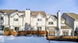 Rear view of house with a chimney, stucco siding, and a tile roof - 