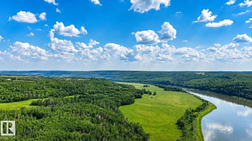 Expansive natural landscape featuring a winding river, dense green forests, and open grassy fields under a clear blue sky with white clouds - Rge Rd 102 Twp Rd 552A, Rural St. Paul County, AB 