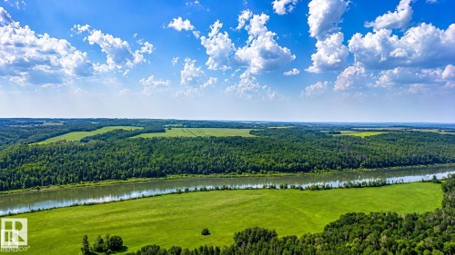 Expansive natural landscape featuring a prominent river, surrounding lush green fields, and dense forest areas under a clear sky - Rge Rd 102 Twp Rd 552A, Rural St. Paul County, AB 