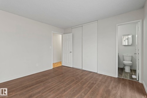 The room features wood-style flooring and light-colored walls - 18124 68Ave, Edmonton, AB - Indoor Photo Showing Other Room