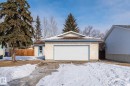 The property features a single-car garage with a white door, a paved driveway, and a stucco exterior - 18124 68Ave, Edmonton, AB  - Outdoor 