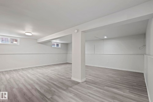 Spacious interior with light wood-style flooring, white walls, and recessed lighting - 18124 68Ave, Edmonton, AB - Indoor