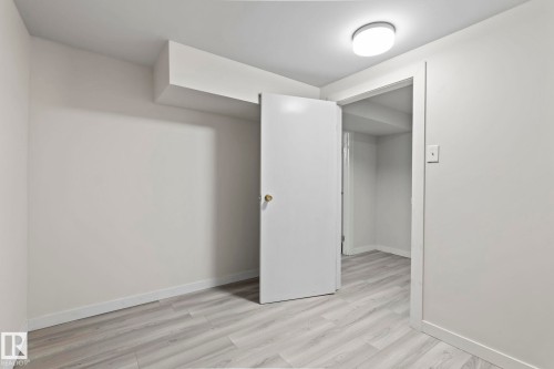Room featuring light-colored walls, light wood-style flooring, and a flush mount ceiling light fixture - 18124 68Ave, Edmonton, AB - Indoor Photo Showing Other Room