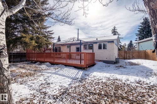 The property features a spacious rear deck with a gazebo, surrounded by mature evergreen trees - 18124 68Ave, Edmonton, AB - Outdoor With Deck Patio Veranda