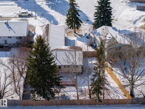 The property features a fenced yard, mature trees, and a deck - 18124 68Ave, Edmonton, AB - Outdoor