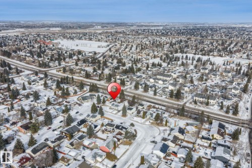 Aerial view of the surrounding neighborhood, featuring numerous properties with snow-covered roofs and mature trees - 18124 68Ave, Edmonton, AB - Outdoor With View