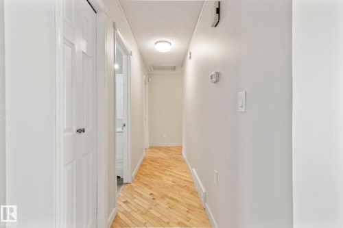 The property features a bright hallway with light-colored walls and wood flooring - 18124 68Ave, Edmonton, AB - Indoor Photo Showing Other Room
