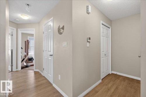 Hallway with light-colored walls and wood-look flooring - 33 4029 Orchards Drive Sw, Edmonton, AB - Indoor Photo Showing Other Room