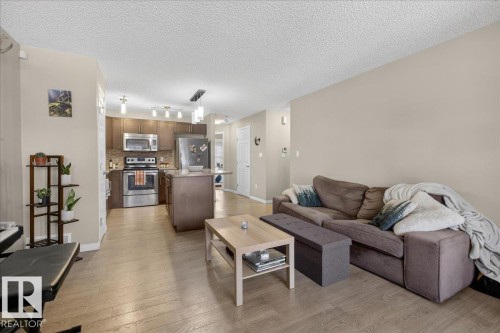 The open-concept living area features light-colored flooring and neutral-toned walls, creating a bright and inviting atmosphere - 33 4029 Orchards Drive Sw, Edmonton, AB - Indoor Photo Showing Living Room