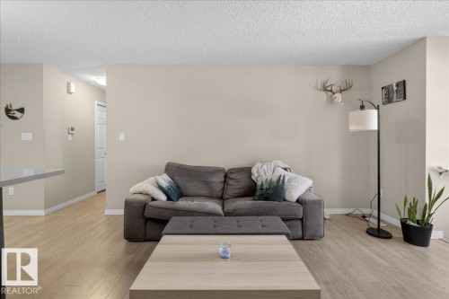 Inviting living area featuring light-colored flooring, neutral wall tones, and a white ceiling - 33 4029 Orchards Drive Sw, Edmonton, AB - Indoor Photo Showing Living Room
