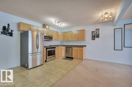 Well-appointed kitchen featuring stainless steel appliances, light wood cabinetry, and a corner sink - 103 309 Clareview Station Drive, Edmonton, AB - Indoor Photo Showing Kitchen