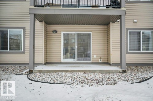 The property features a concrete patio area with direct access via sliding glass doors - 103 309 Clareview Station Drive, Edmonton, AB - Outdoor With Balcony With Exterior
