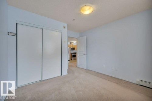 This room features light blue walls, a neutral carpet, and a ceiling-mounted light fixture - 103 309 Clareview Station Drive, Edmonton, AB - Indoor Photo Showing Other Room