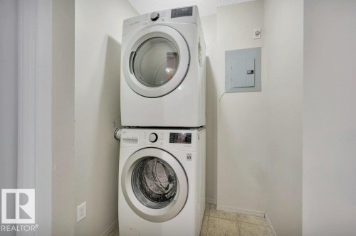 The property features a dedicated laundry area with a stacked washer and dryer, providing convenience - 103 309 Clareview Station Drive, Edmonton, AB - Indoor Photo Showing Laundry Room