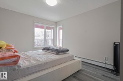 Bedroom featuring a baseboard heating unit, a textured ceiling, and dark wood finished floors - 