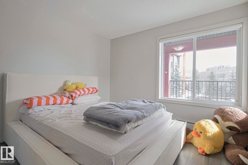 Bedroom with wood finished floors, a textured ceiling, and baseboard heating - 236 344 Windermere Road, Edmonton, AB - Indoor Photo Showing Bedroom