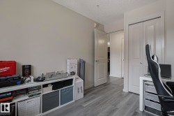 Home office featuring light wood finished floors and a textured ceiling - 