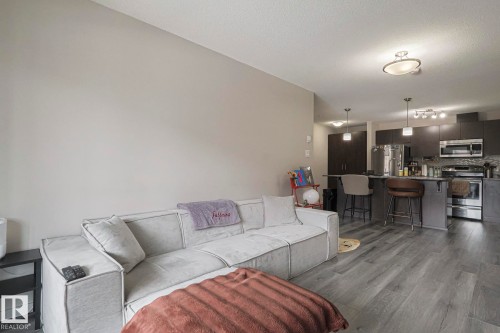 Living area featuring dark wood-type flooring - 236 344 Windermere Road, Edmonton, AB - Indoor Photo Showing Living Room