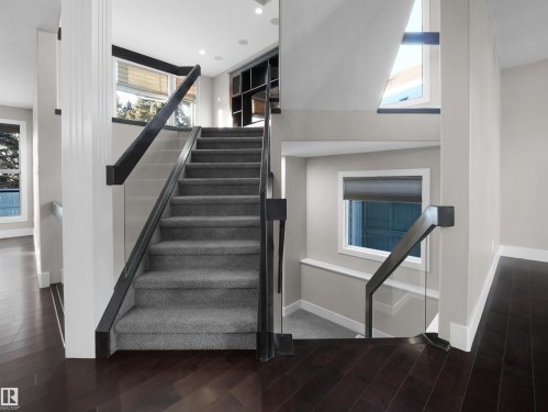 Stairway featuring wood finished floors, a high ceiling, and recessed lighting - 59 10550 Ellerslie Road, Edmonton, AB - Indoor Photo Showing Other Room
