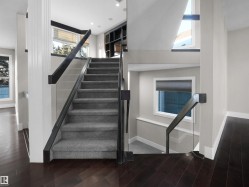 Stairway featuring wood finished floors, a high ceiling, and recessed lighting - 