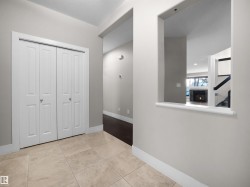 Hall featuring baseboards and light tile patterned floors - 