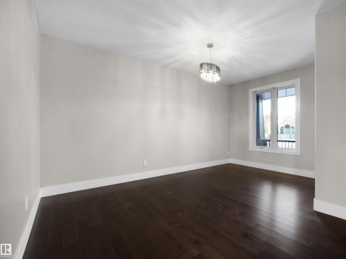 Dining room featuring a chandelier and dark wood flooring - 59 10550 Ellerslie Road, Edmonton, AB - Indoor Photo Showing Other Room