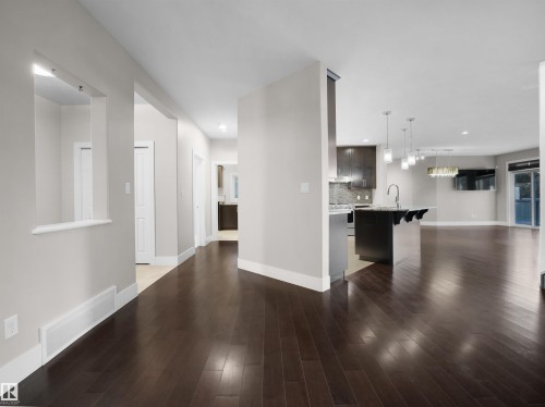 Unfurnished living room with dark wood-style floors and recessed lighting - 59 10550 Ellerslie Road, Edmonton, AB - Indoor Photo Showing Other Room