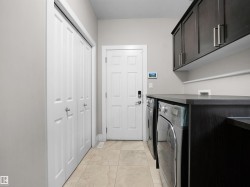 Laundry area with light tile patterned flooring, cabinet space, and separate washer and dryer - 