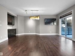 Unfurnished dining area with dark wood-style floors and track lighting - 