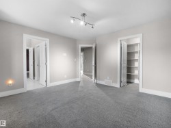 Unfurnished bedroom with a spacious closet and light carpet - 